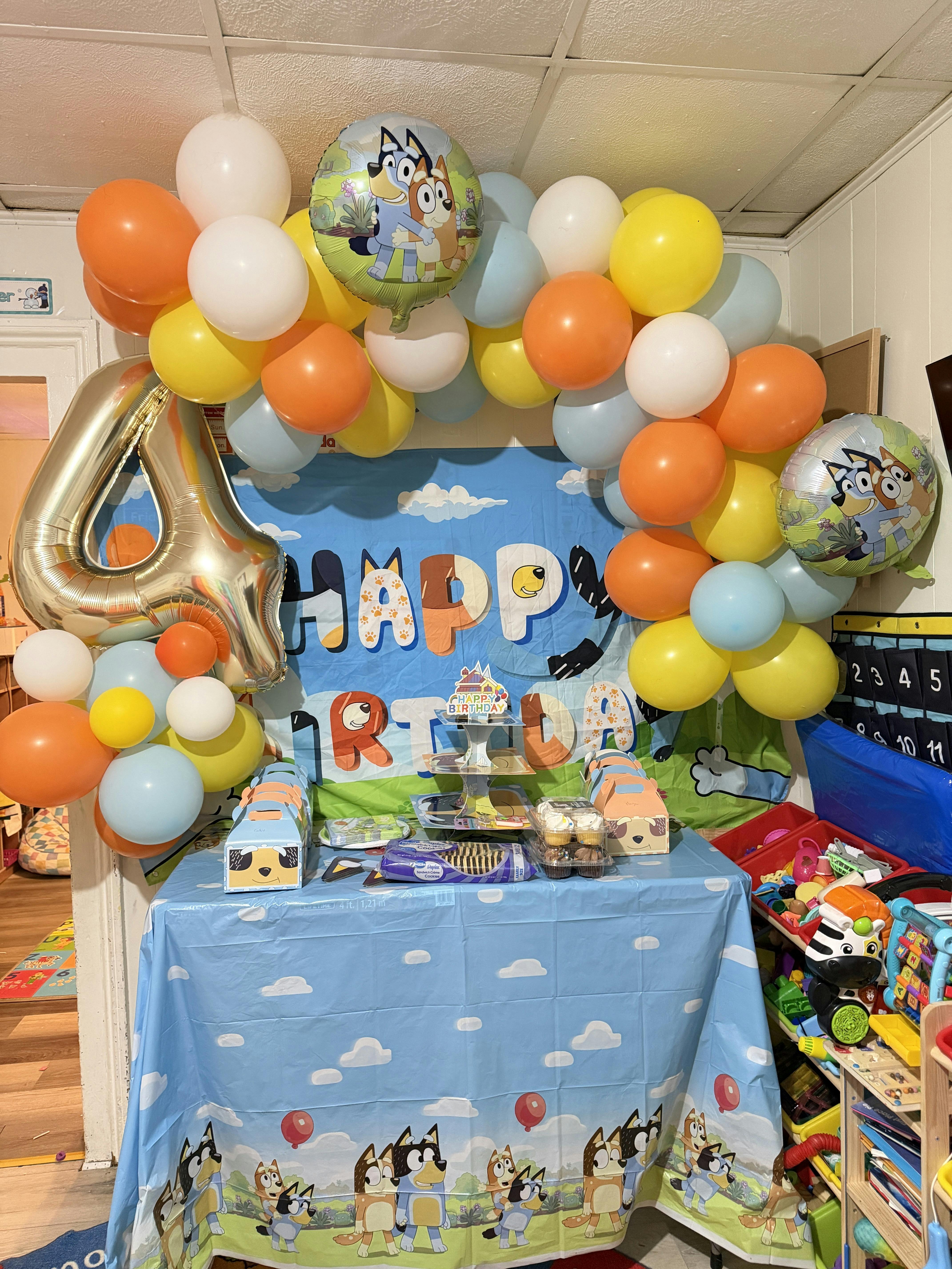 Birthday party decorations with a large number 4 balloon and "Happy Birthday" banner