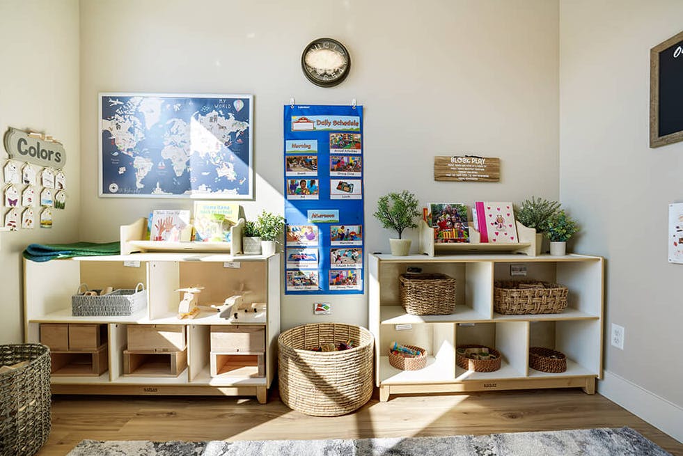 Classroom with child-sized bookshelves, a world map, and a daily schedule chart
