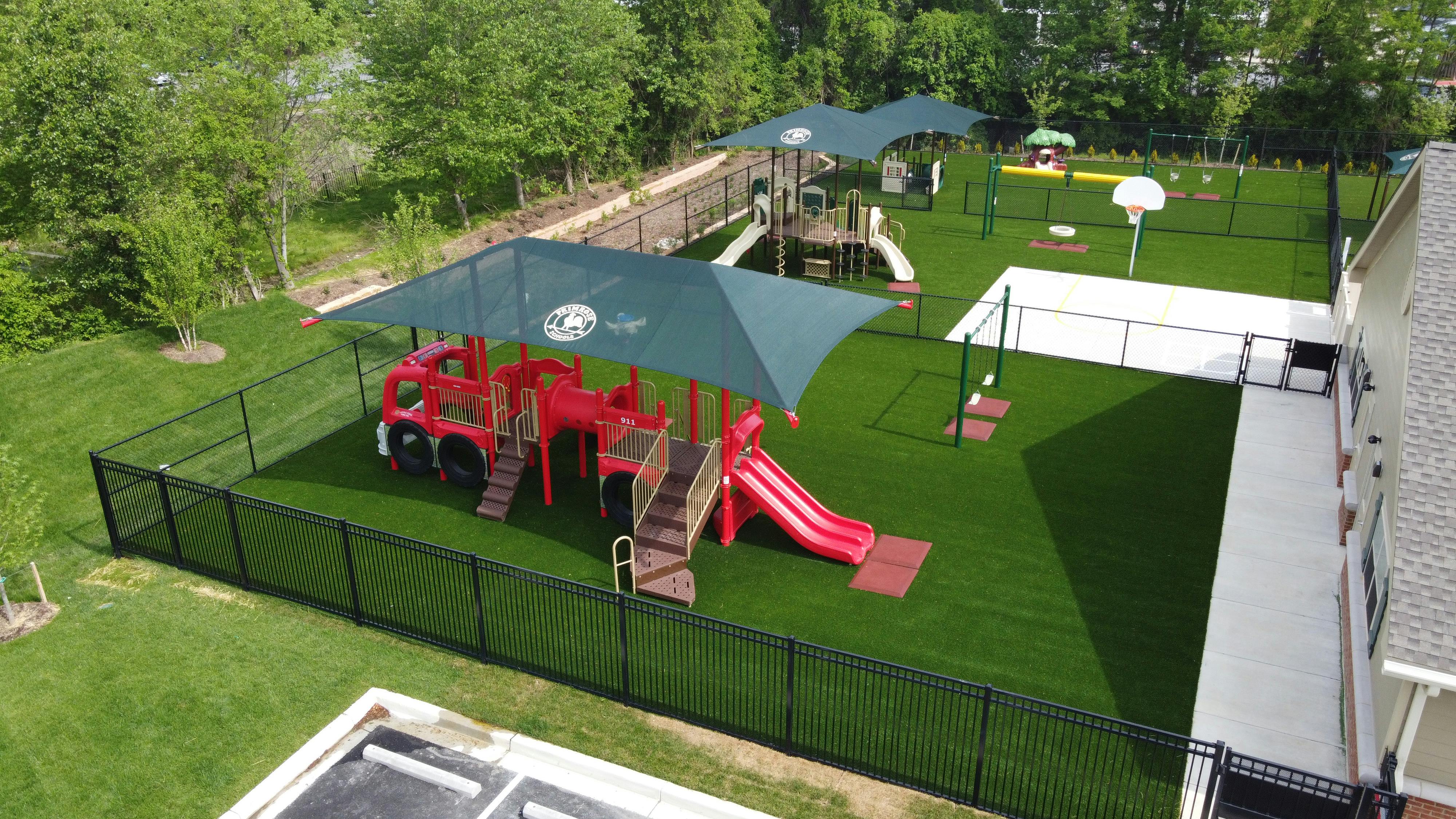 Outdoor playground with red fire truck play structure and slides