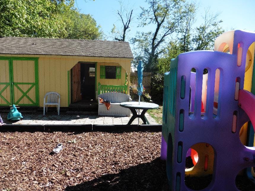 Playground with a colorful play structure and a small shed