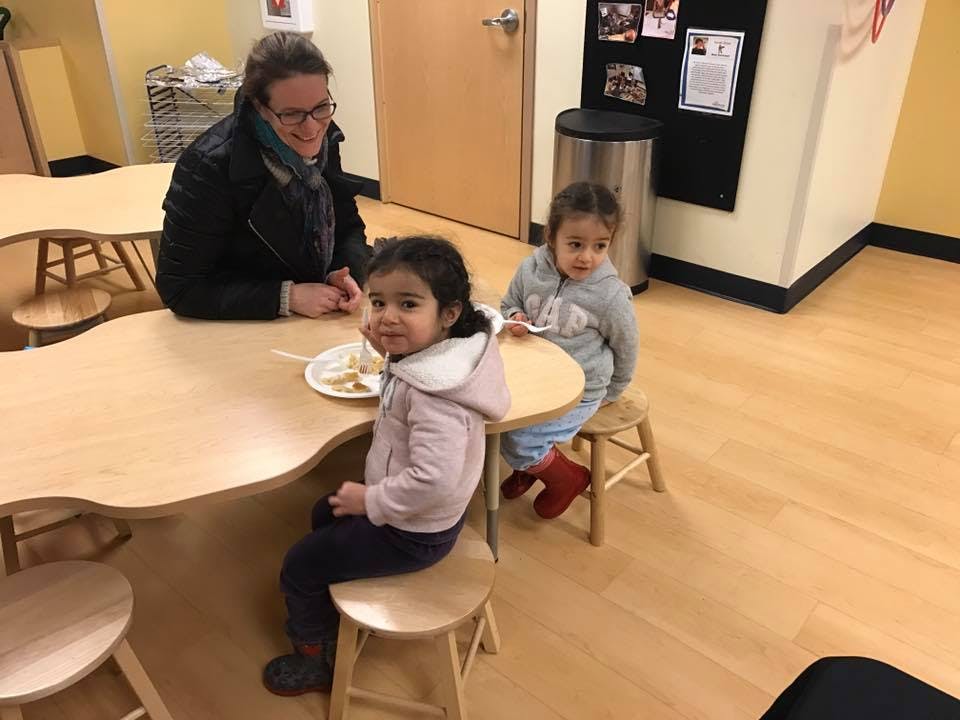 Adult and two children sitting at a table