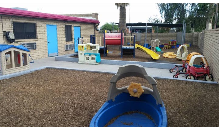 Outdoor playground with slides, playhouses, and ride-on toys