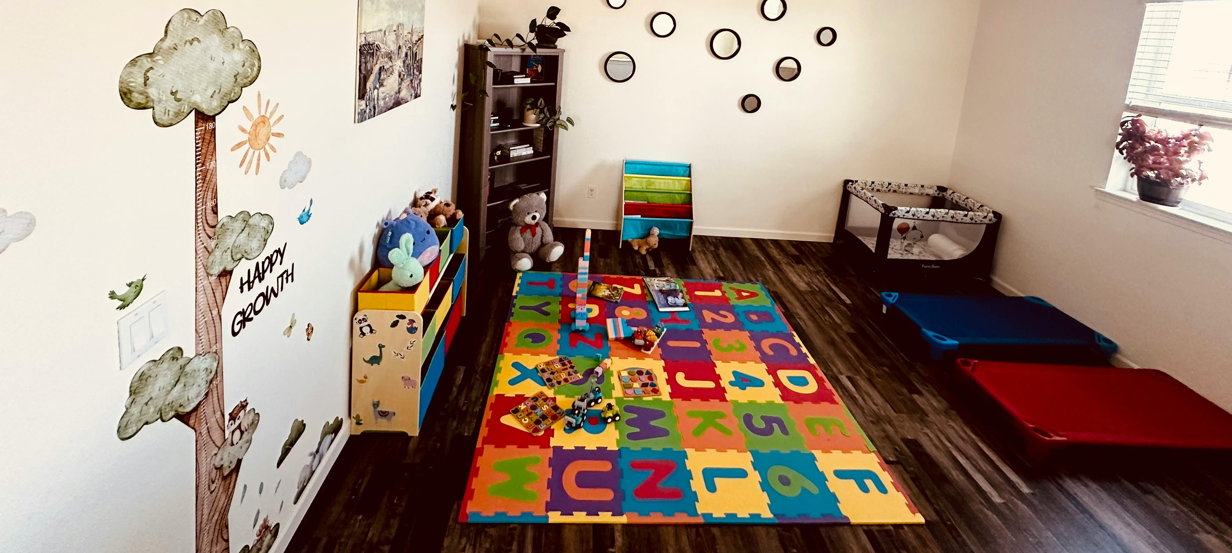 Child's playroom with alphabet mat, crib, and wall decorations