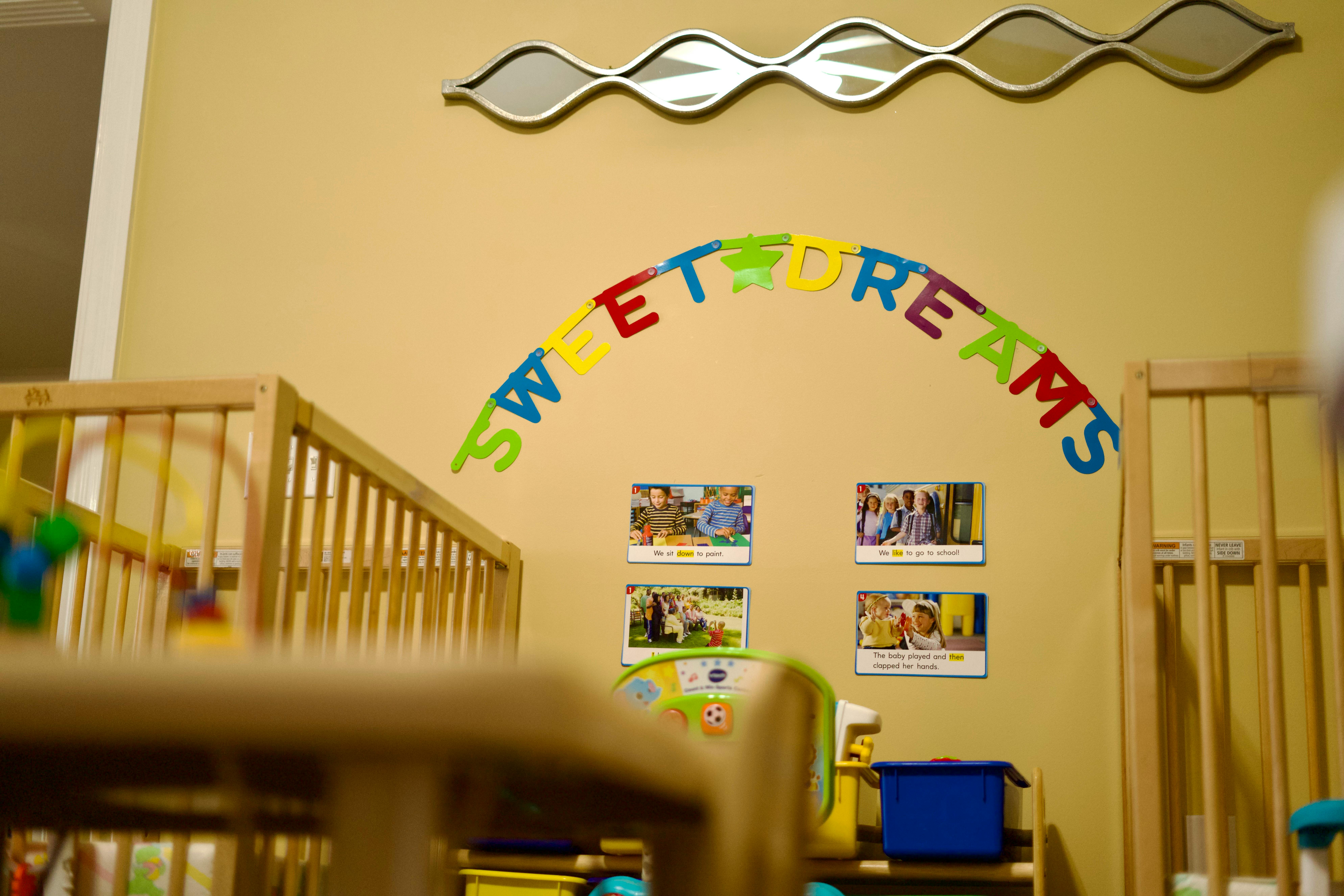 Cribs in a room with "Sweet Dreams" text on the wall