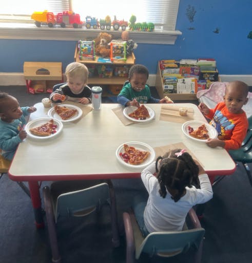 Children eating pizza at a table