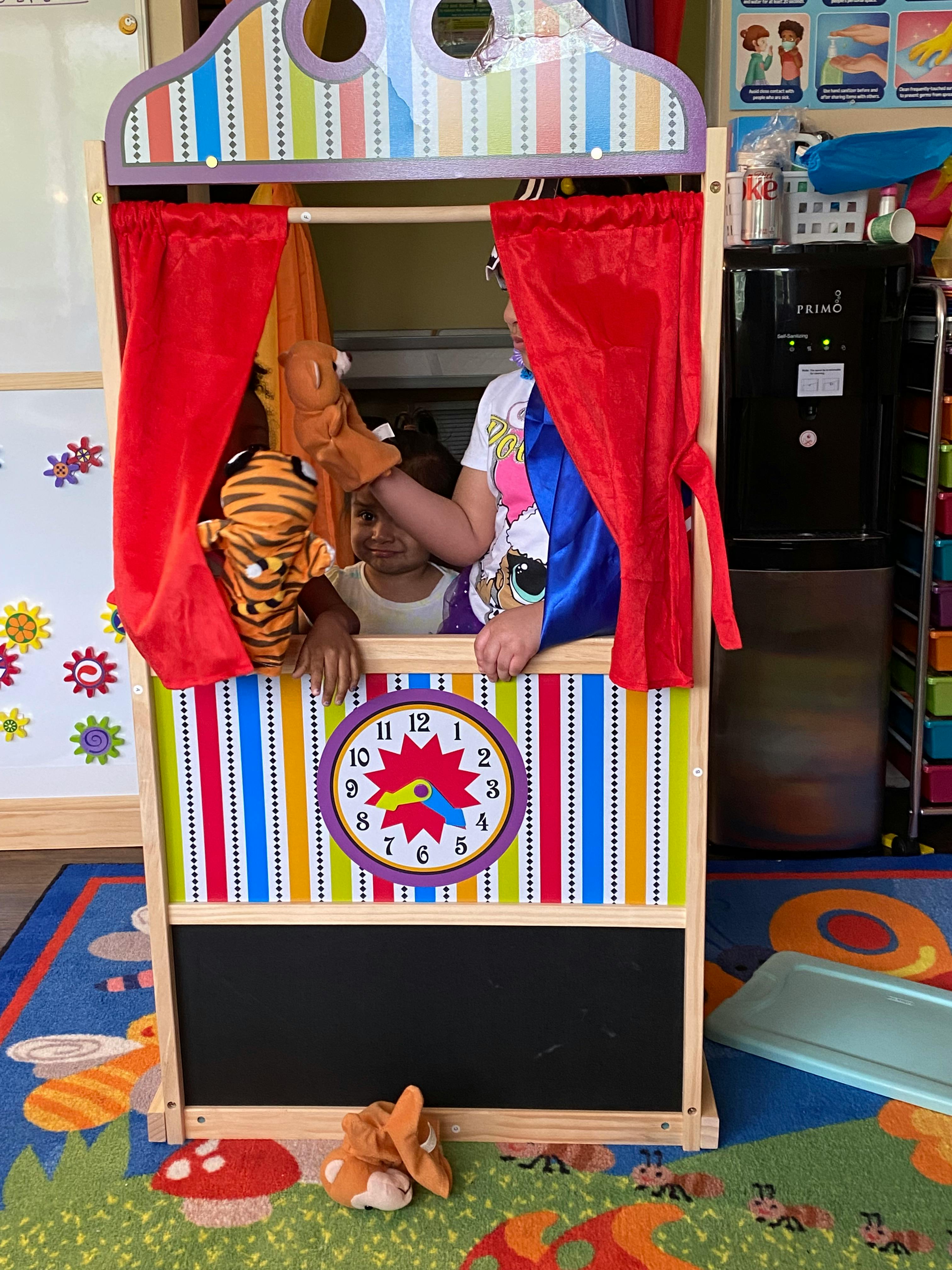 People using hand puppets in a toy puppet theater