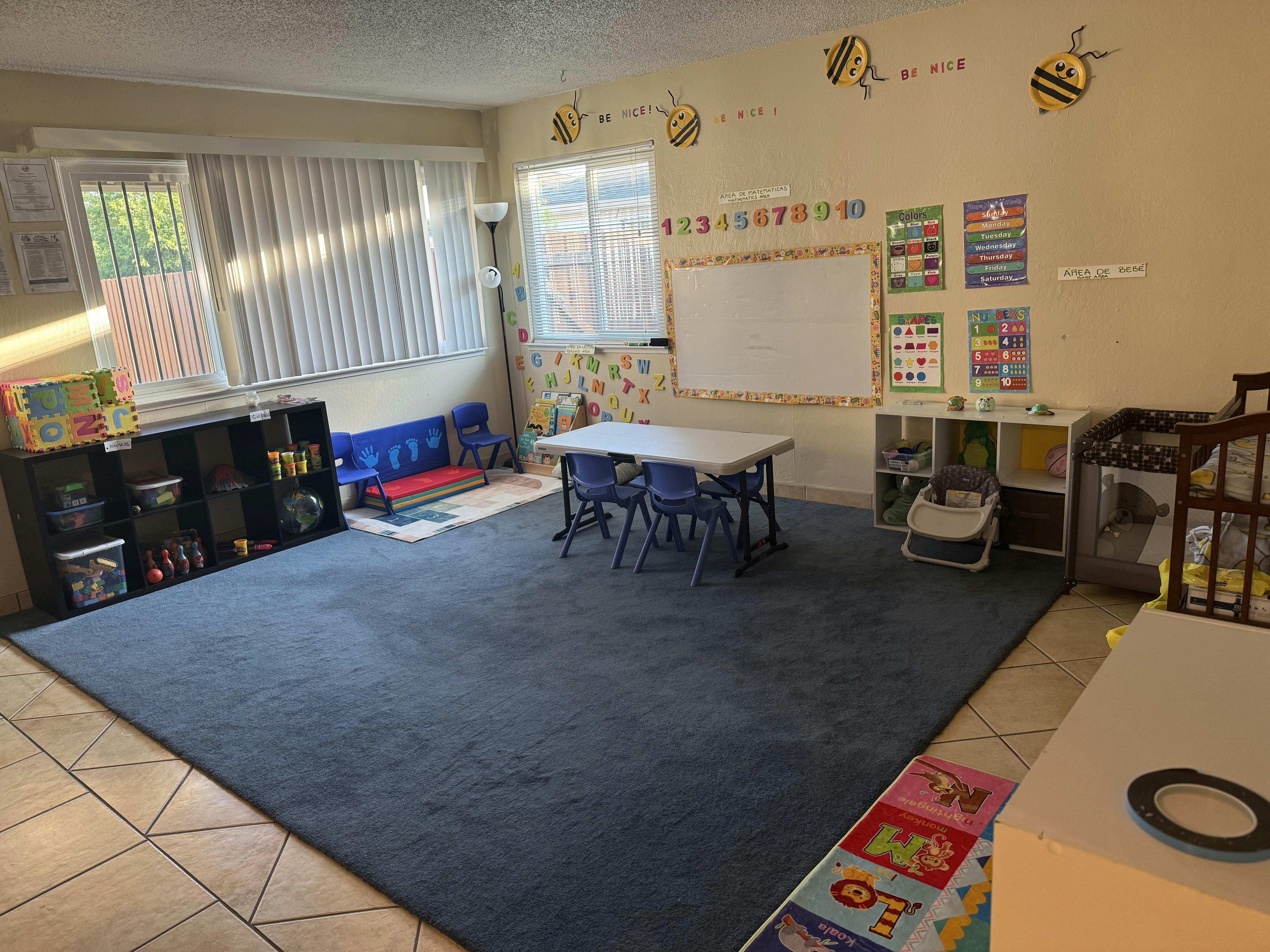 Classroom with a large rug, tables, chairs, and learning materials