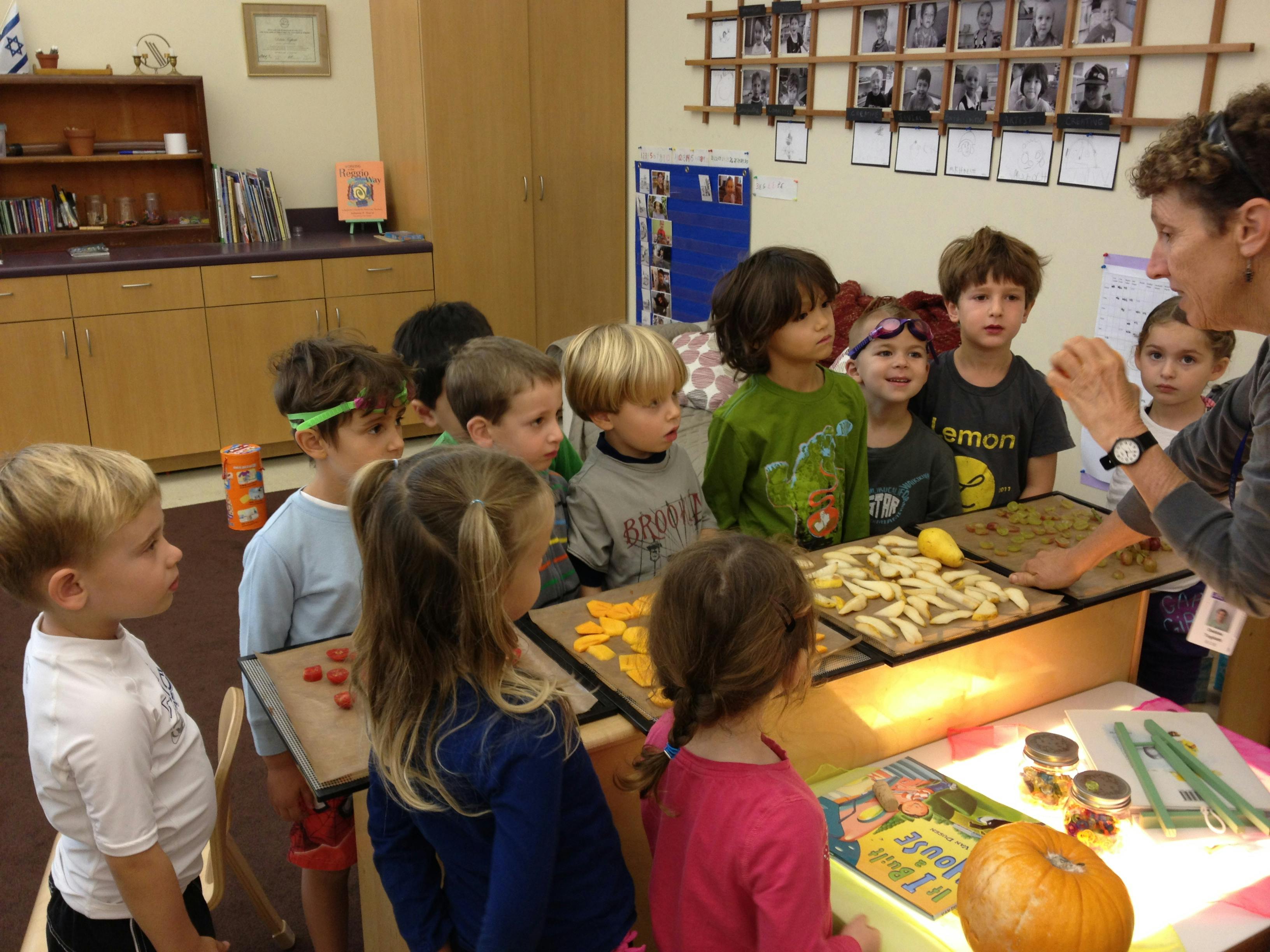 Adult person showing items on a light table to a group of children