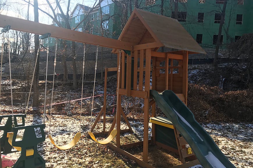 Wooden playground set with swings and a slide