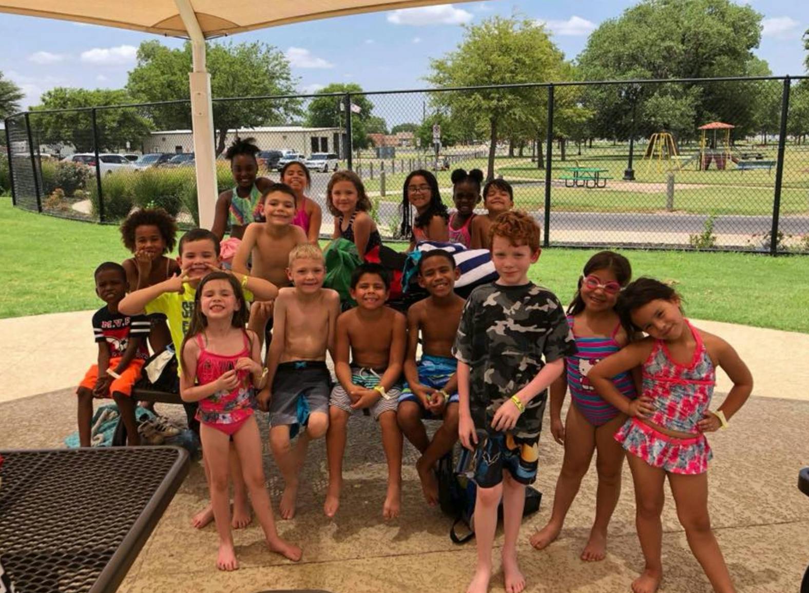 Group of children and teens posing for a photo outdoors