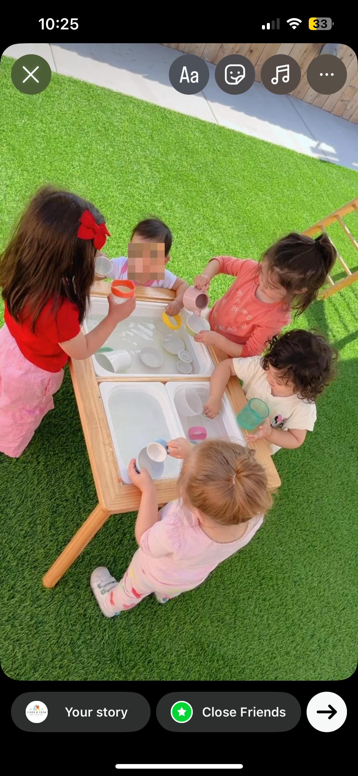 Four children playing with water at a sensory table outdoors
