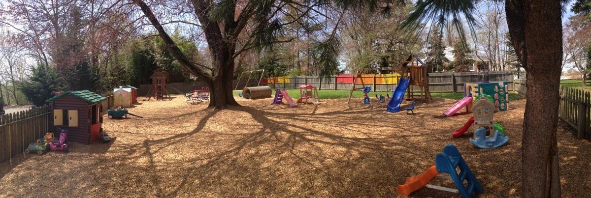 Outdoor playground with slides, swings, and a playhouse