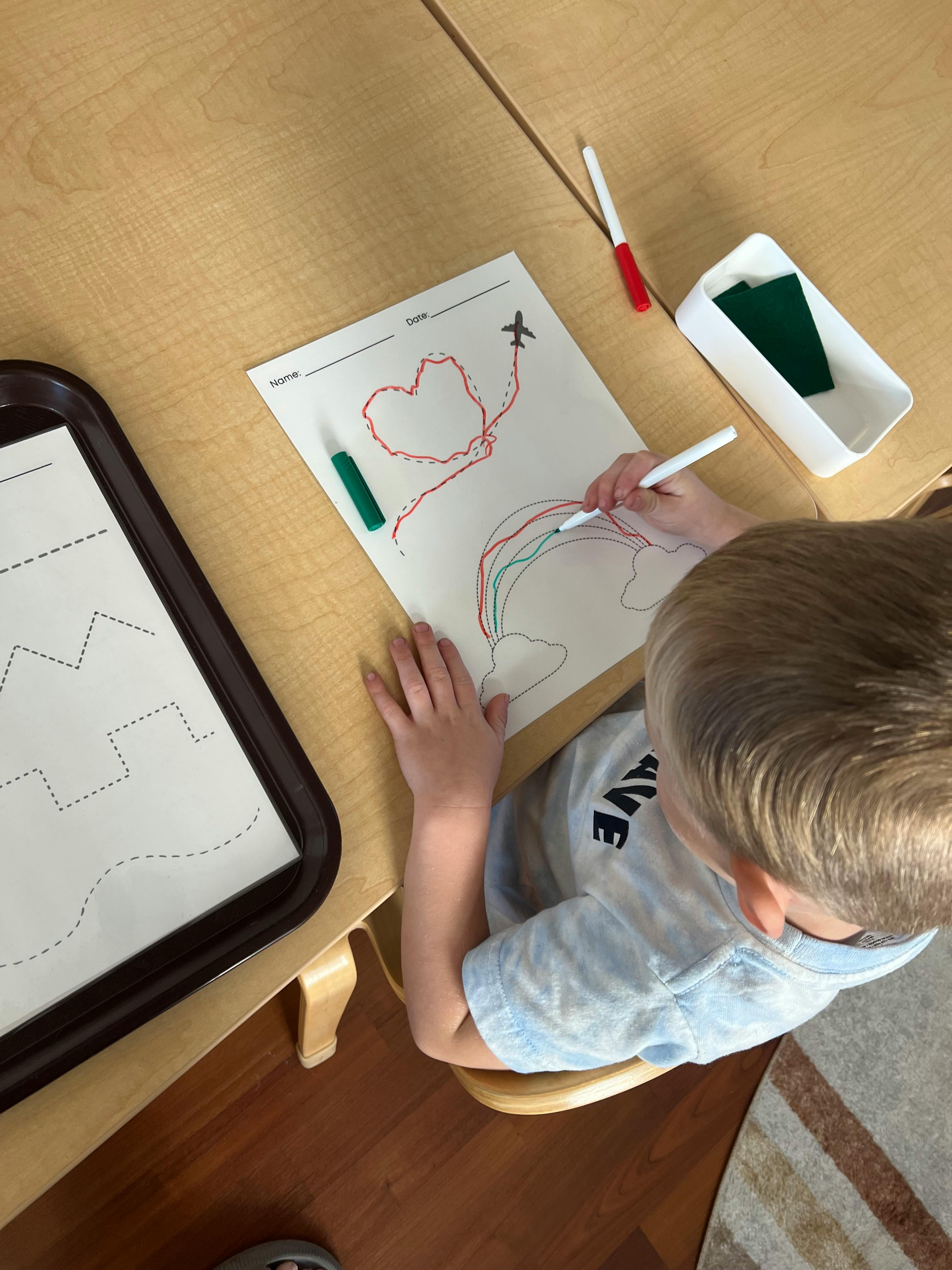 Child drawing on paper at a table
