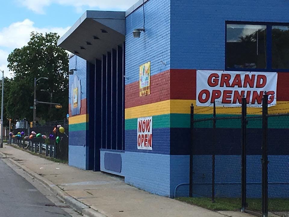 Building with "Grand Opening" and "Now Open" signs