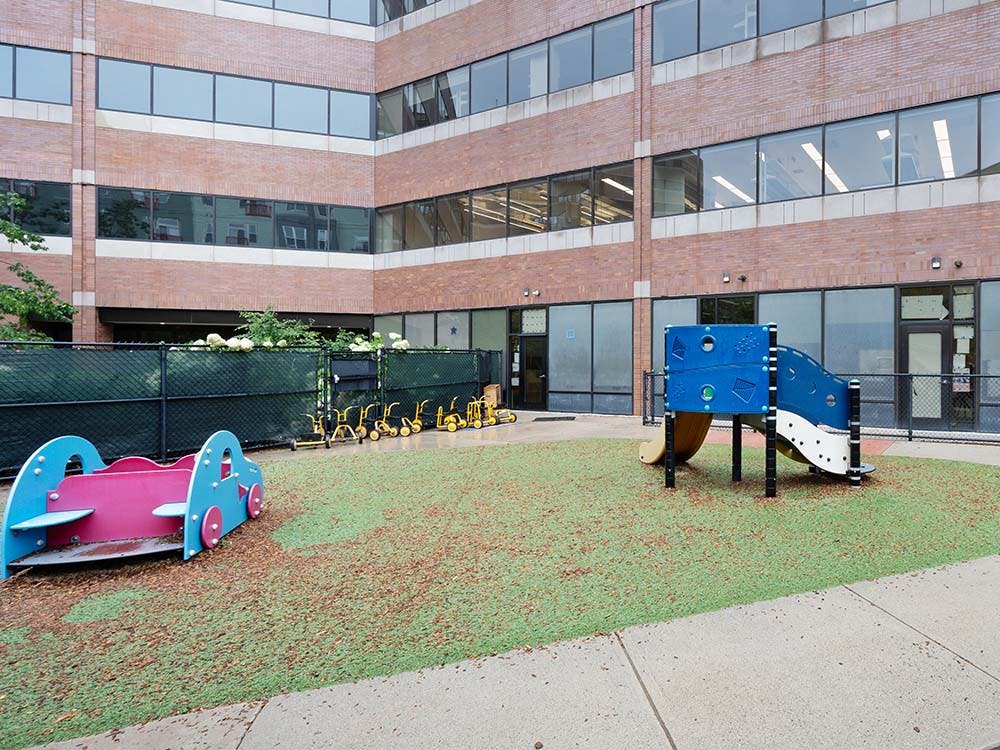 Playground with slides and tricycles in an enclosed area