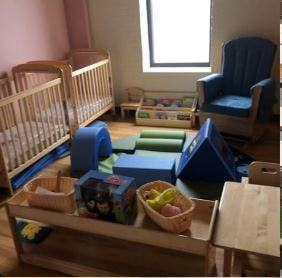Two cribs and soft play equipment in a room