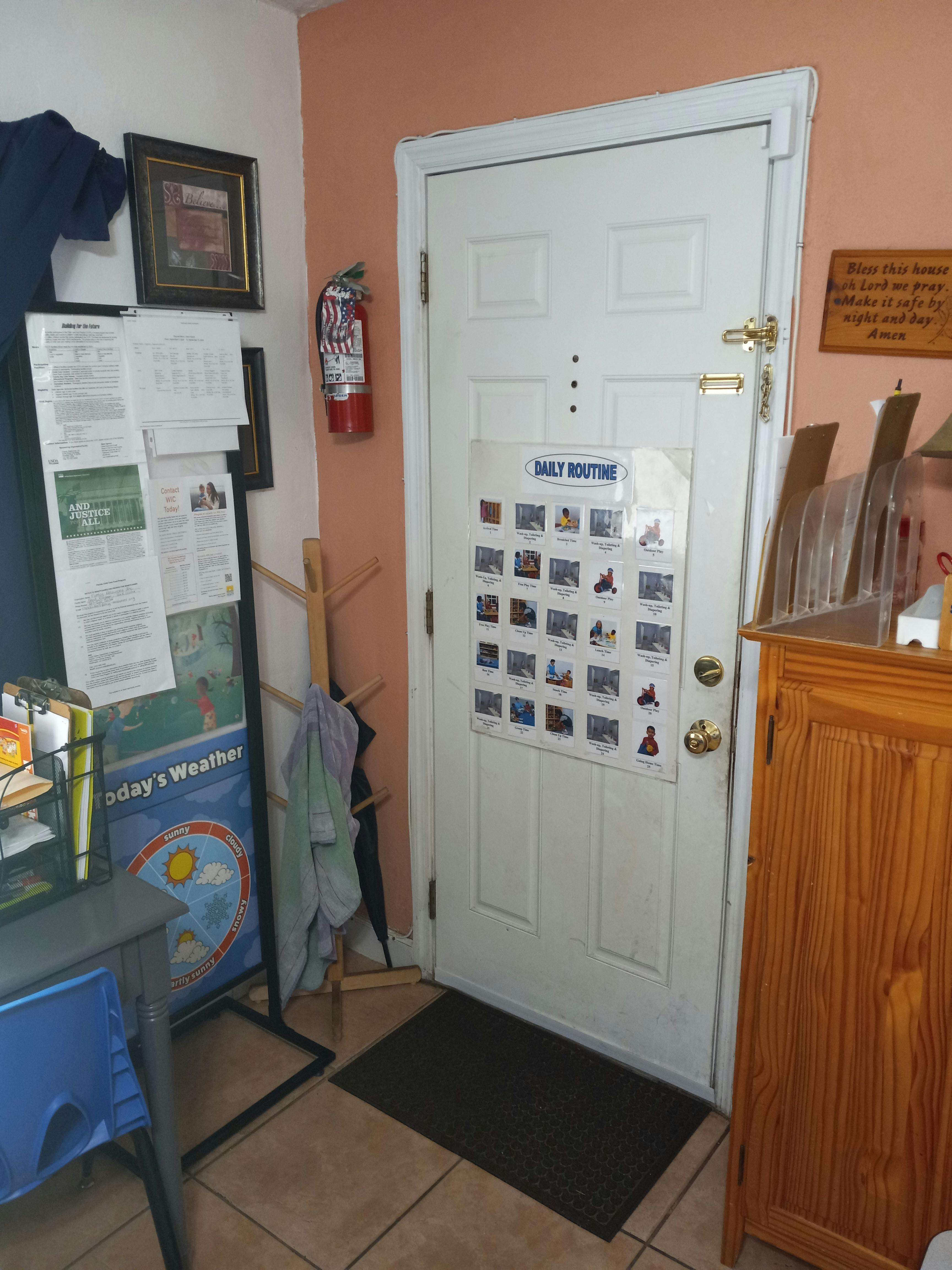 White door with a "Daily Routine" chart, fire extinguisher on wall