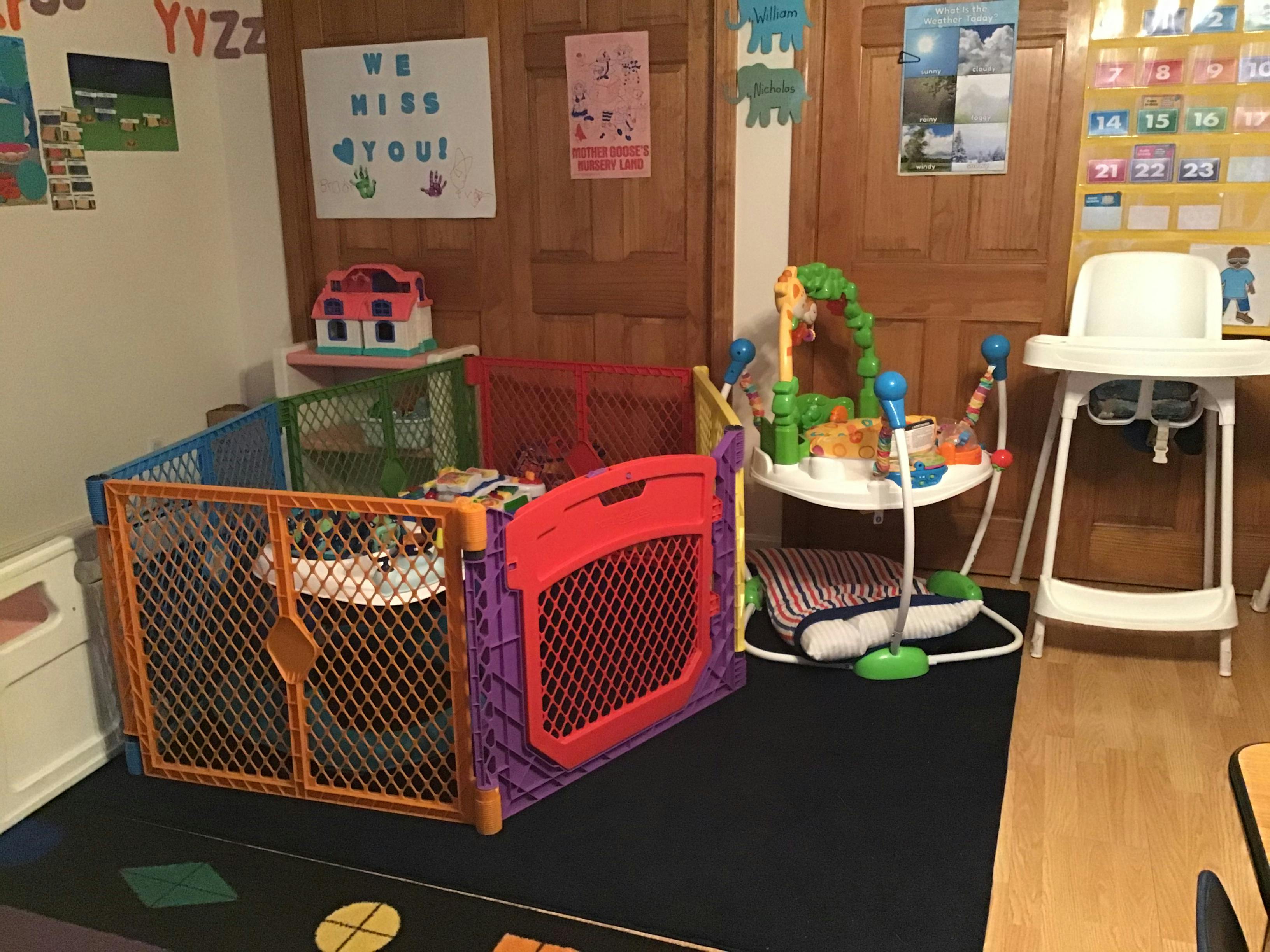 Playpen, baby bouncer, and high chair in a room