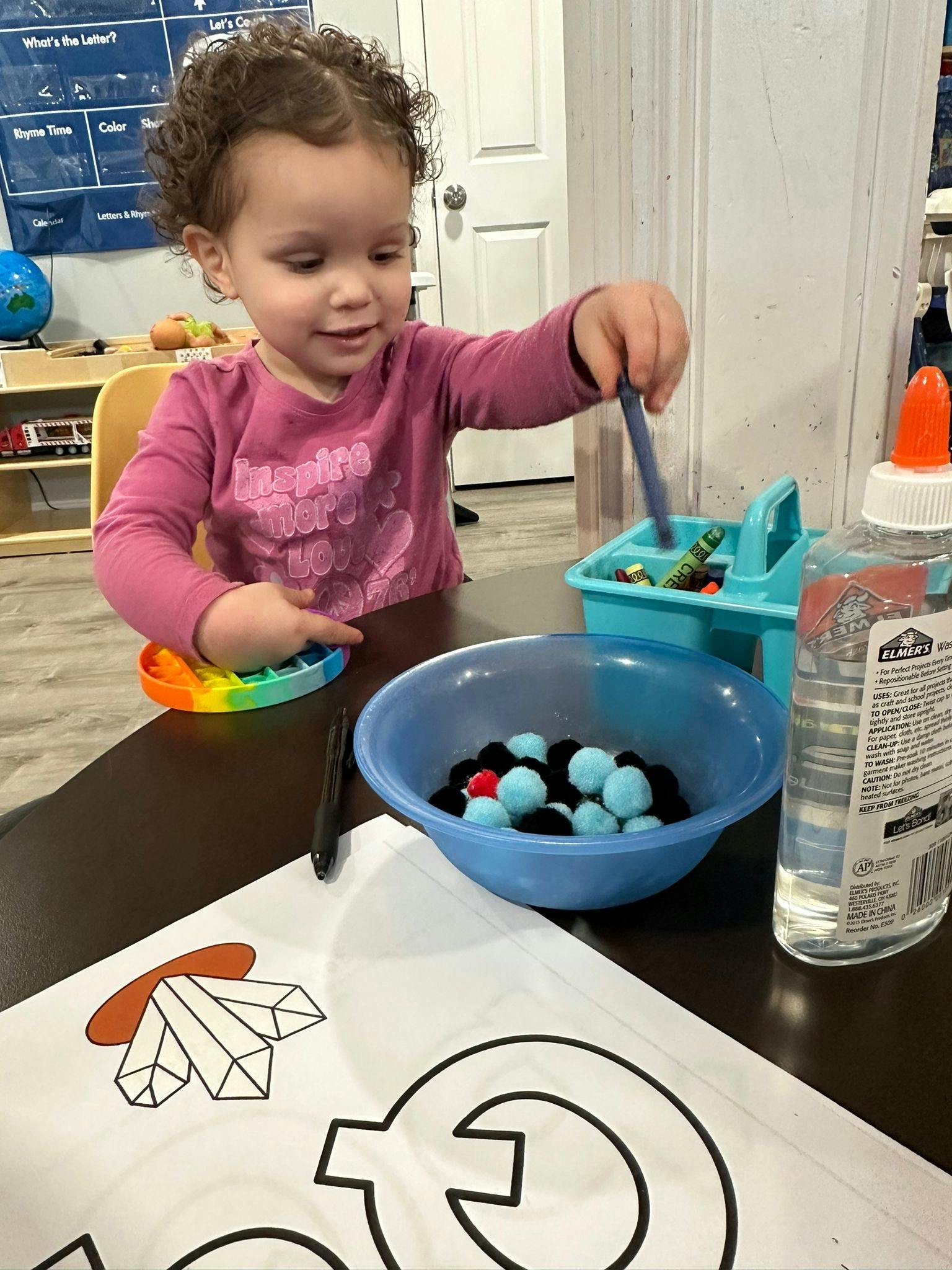 Child playing with craft supplies at a table