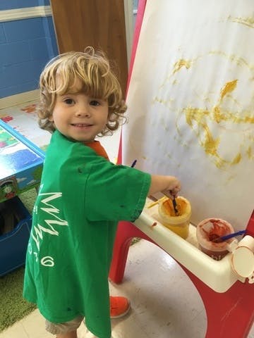 Child painting on an easel