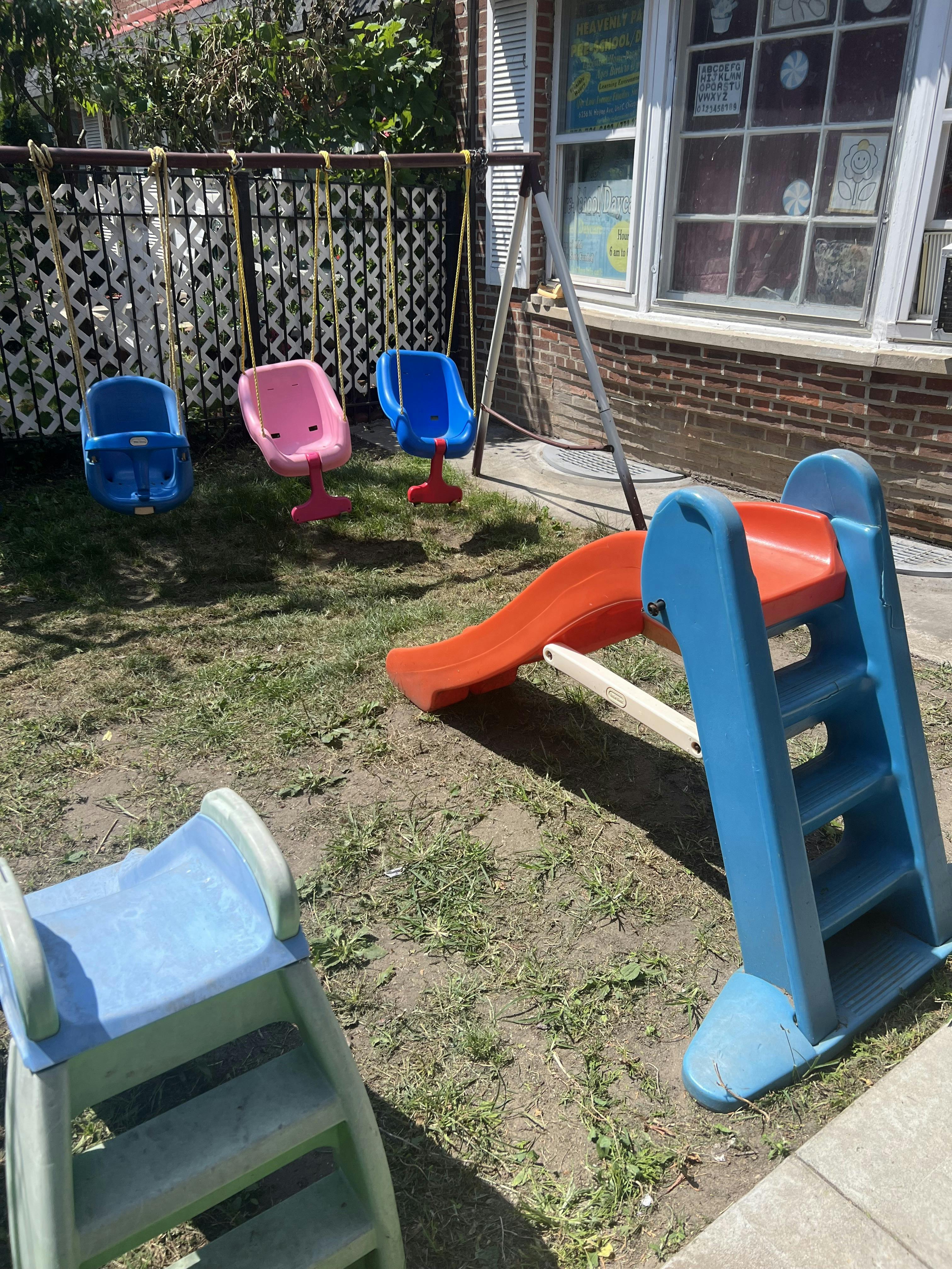 Plastic toddler swings and slides in a backyard playground
