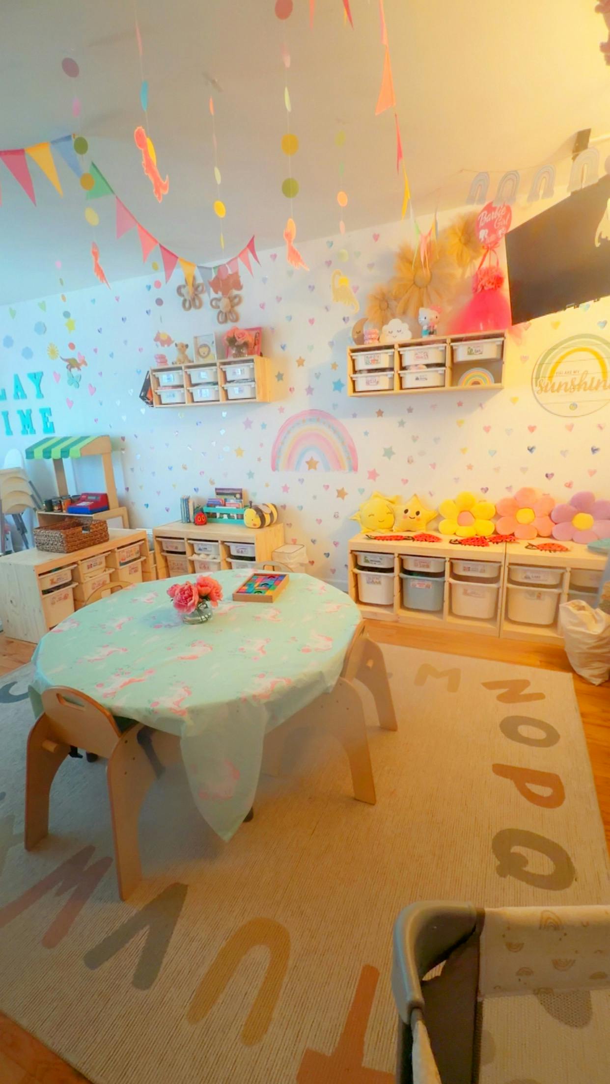 Child playroom with tables and chairs over an alphabet rug