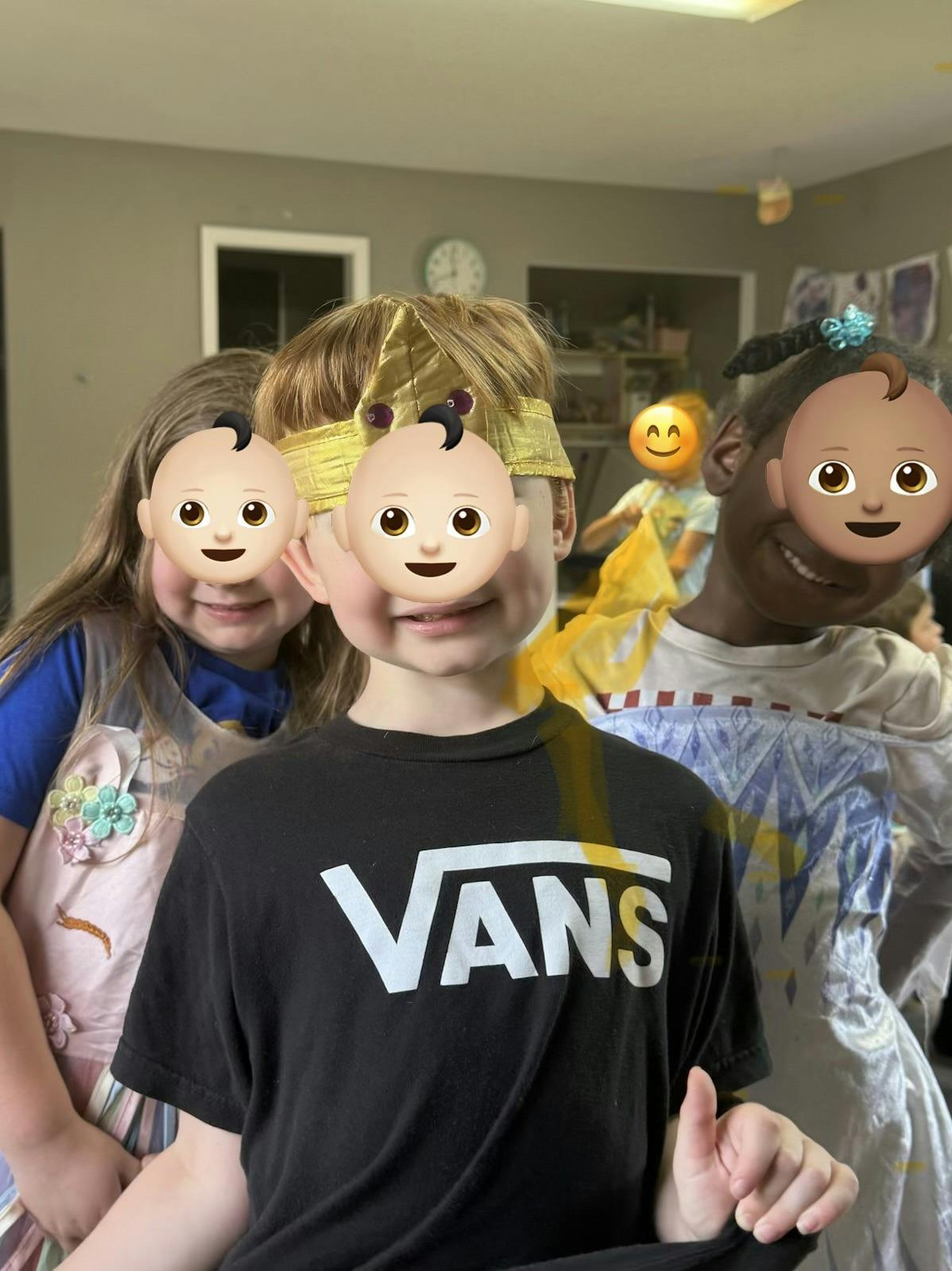 Three children in costumes including a gold crown