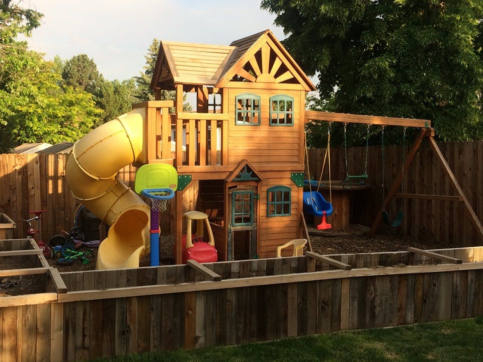 Wooden playground with slide, swings, and playhouse