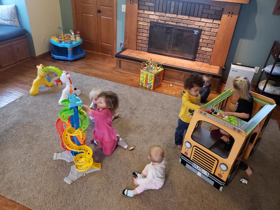 Multiple children playing with toys on a carpeted floor