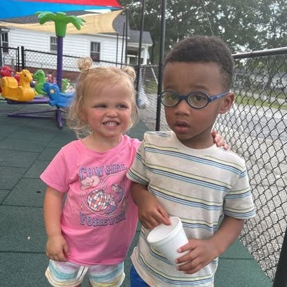 Two children standing together on a playground