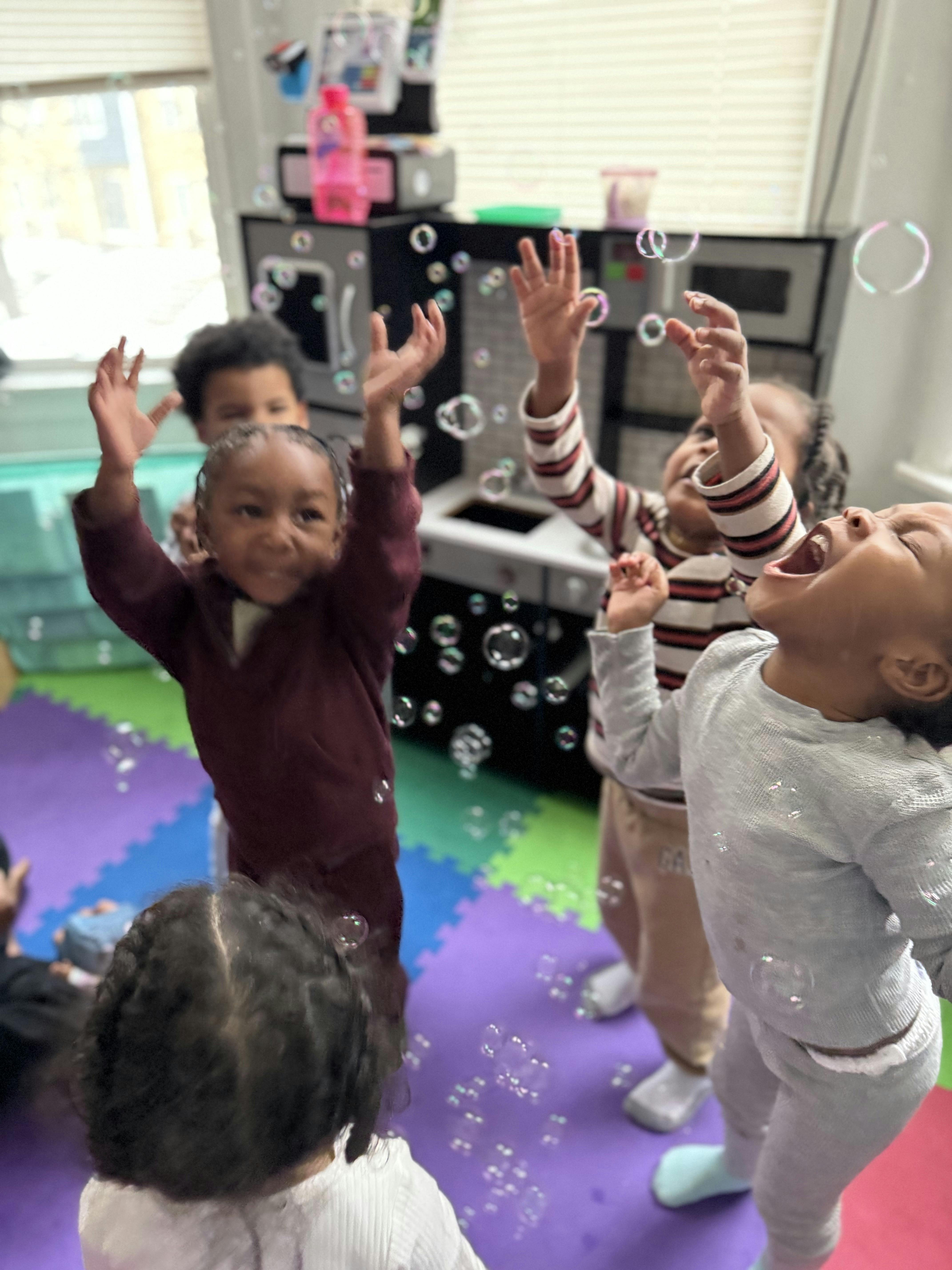 Children playing with bubbles in a classroom