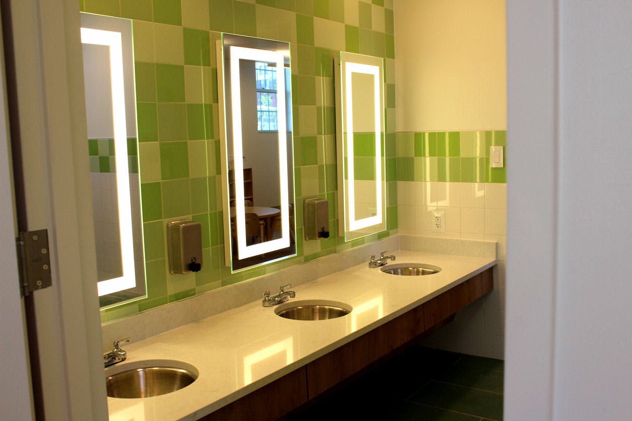Bathroom vanity with three sinks and three mirrors with illuminated borders