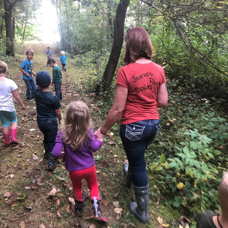 Adult and children walking on a path in a wooded area