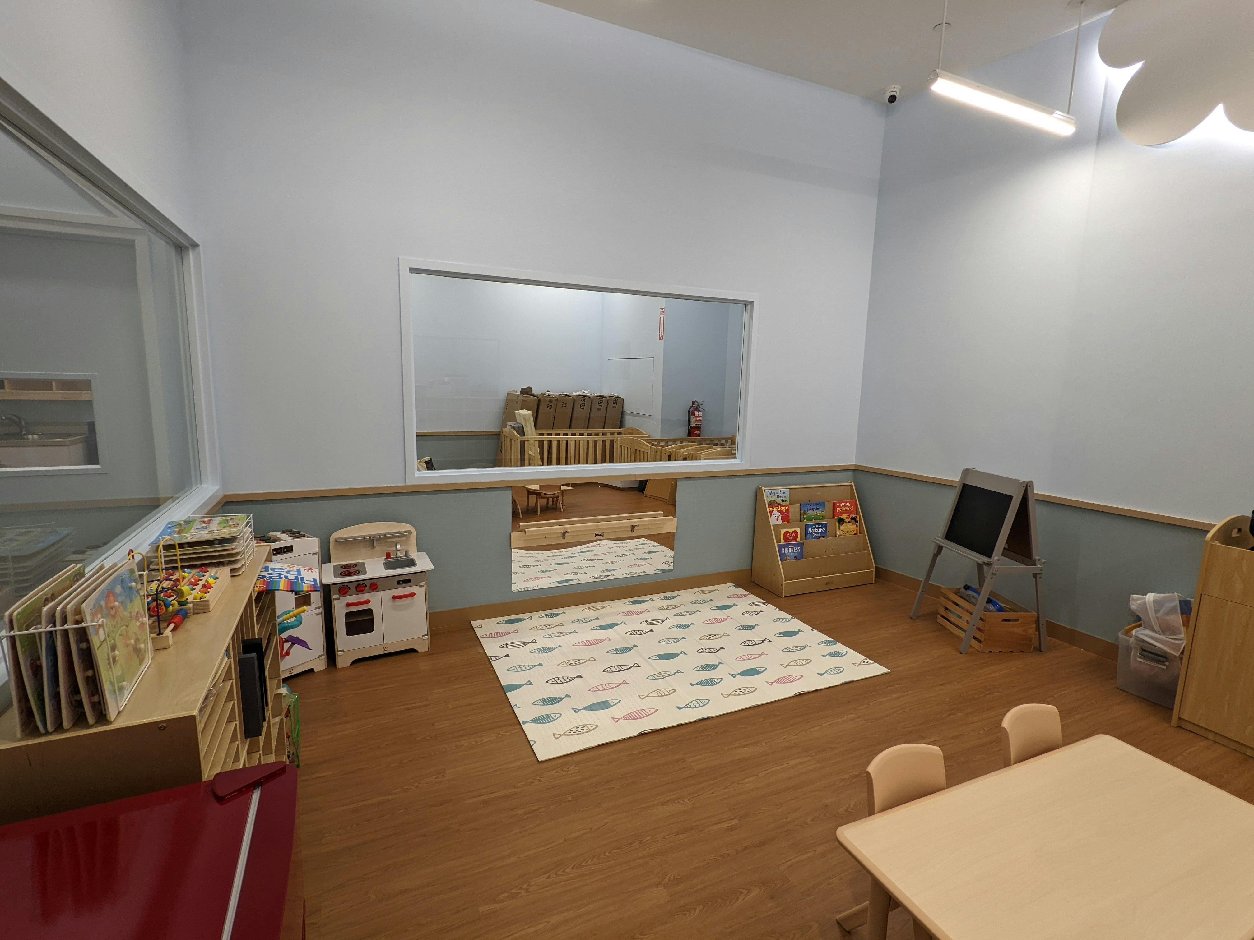 Playroom with a rug, small table and chairs, and toy kitchen