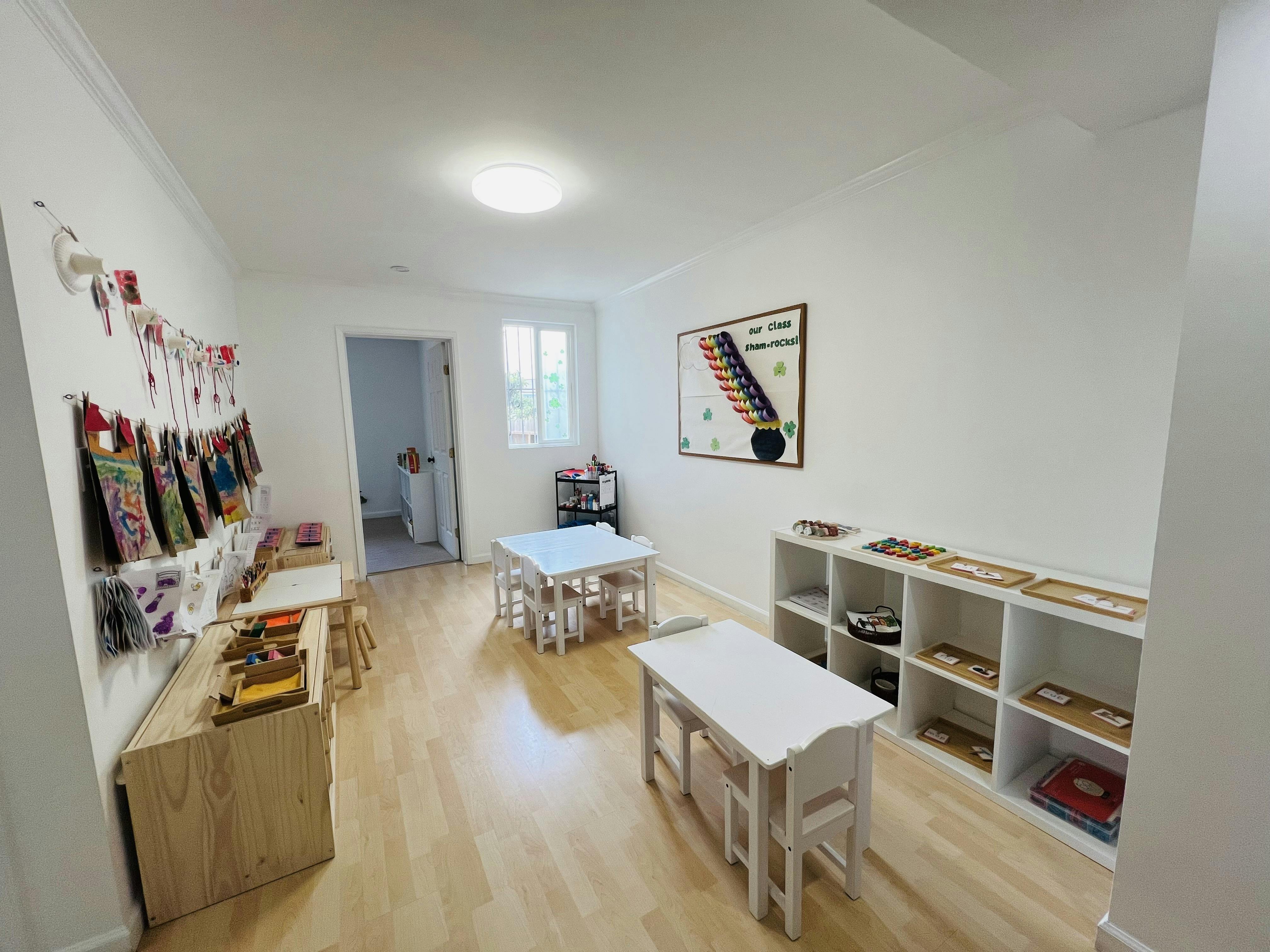 Classroom interior with small tables, chairs, and shelves