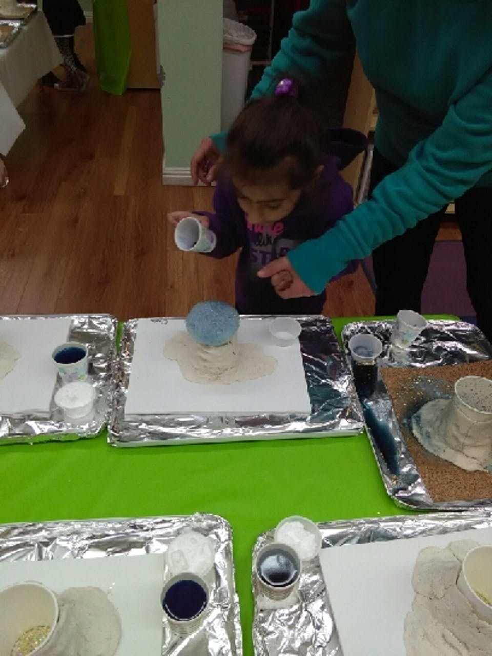 Adult and child doing an art project with blue and white materials