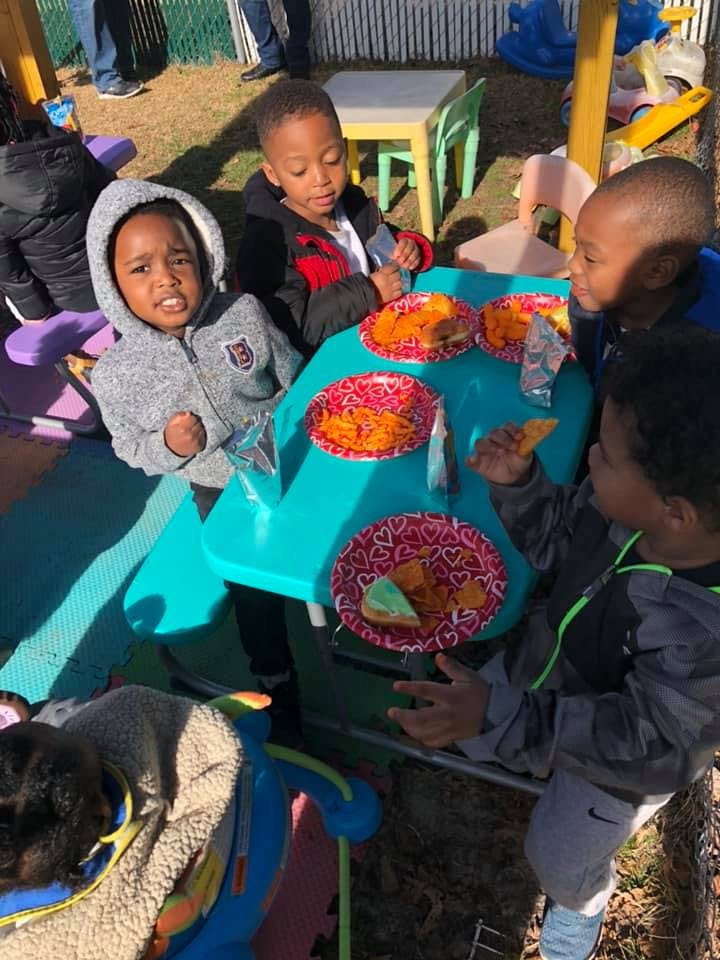 Children sitting at a small table with plates of food
