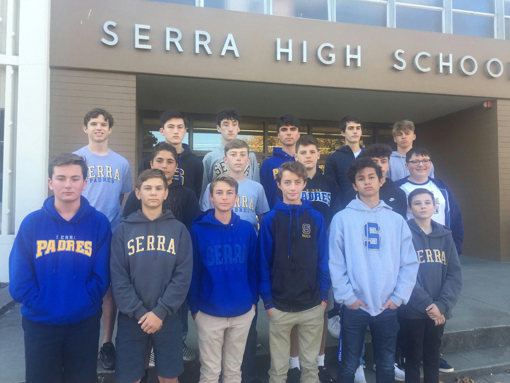 Group of teens wearing Serra High School gear standing in front of the school