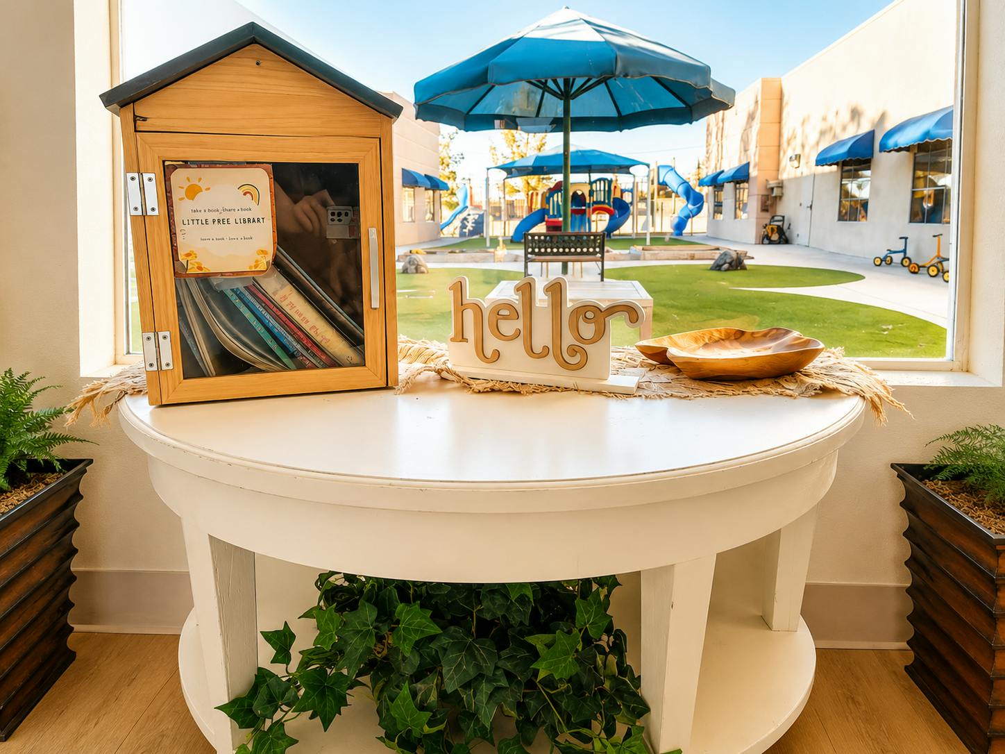 Little Free Library box with books on a table overlooking a playground