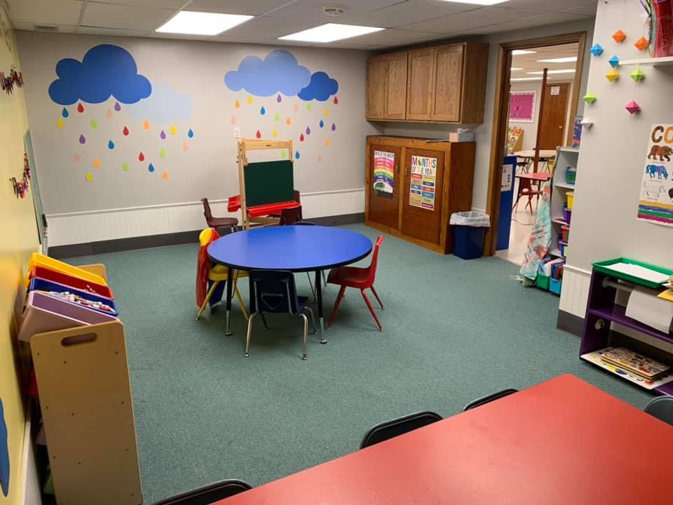 Classroom with blue round table and chairs, cloud and raindrop wall decals