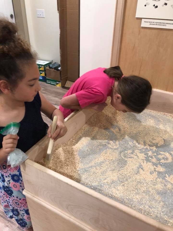 Two children playing in a sand table