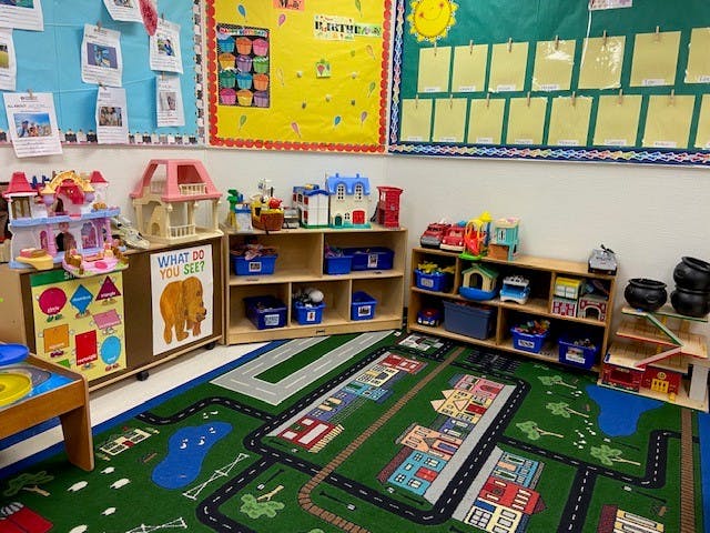 Playroom with toys, shelves, and a road-themed rug