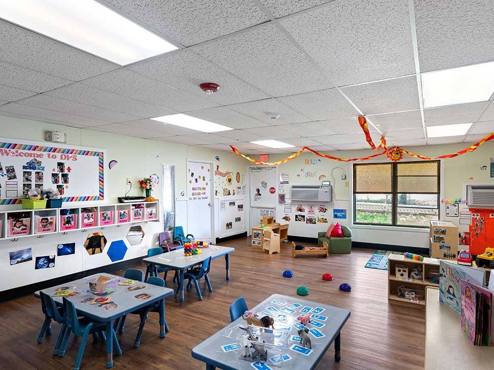Classroom with small tables, chairs, and learning materials