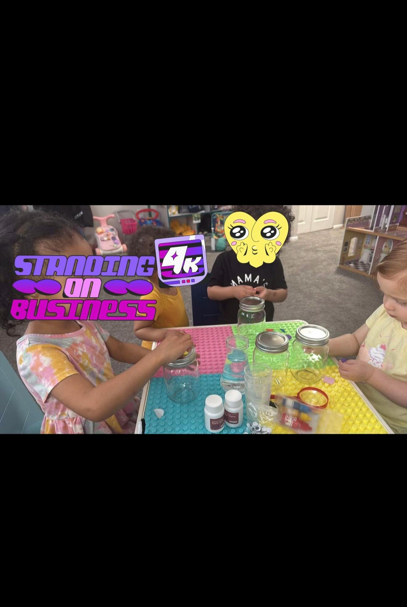 Three children at a table with jars and small containers