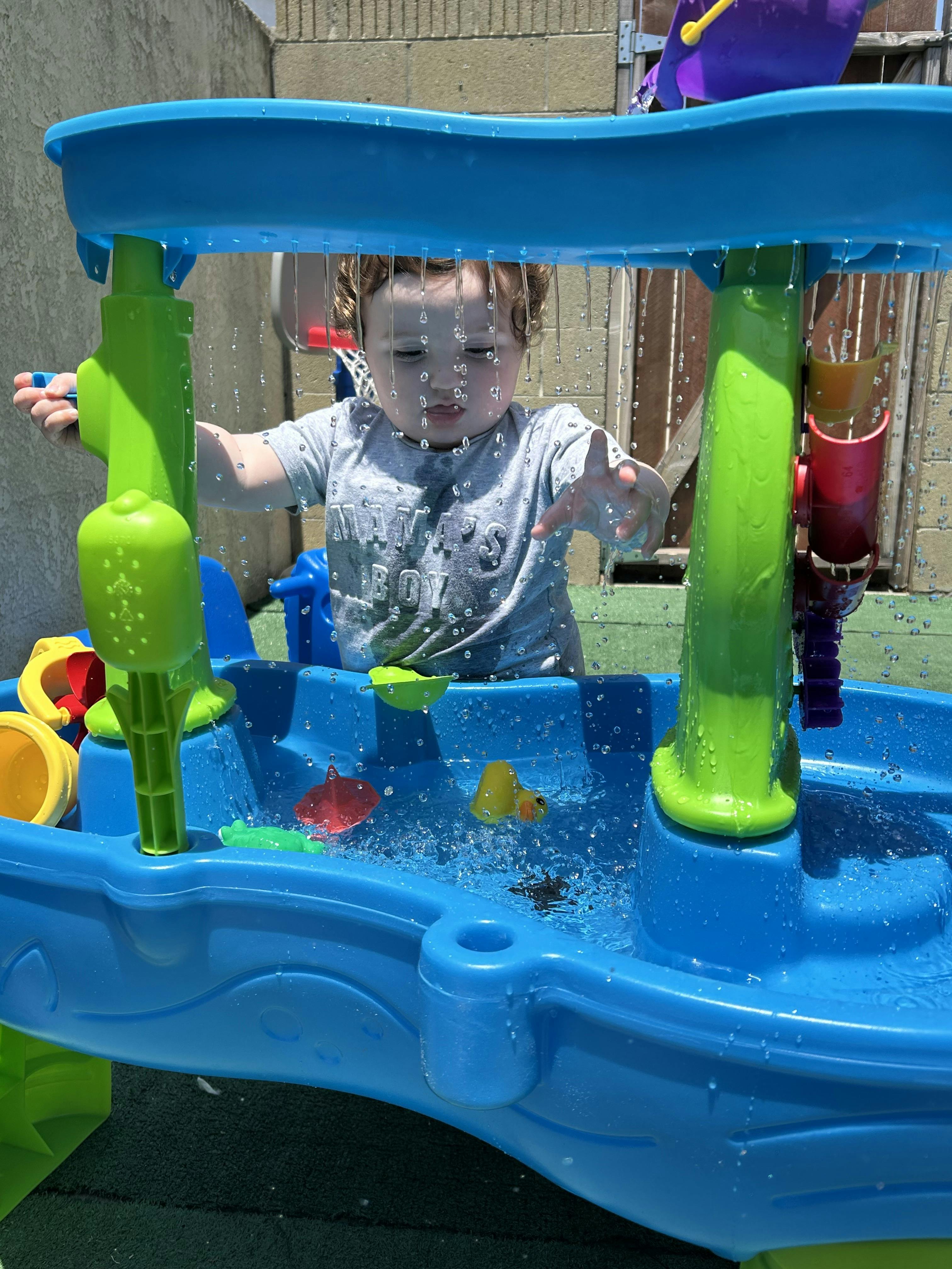Child playing at a water table outdoors