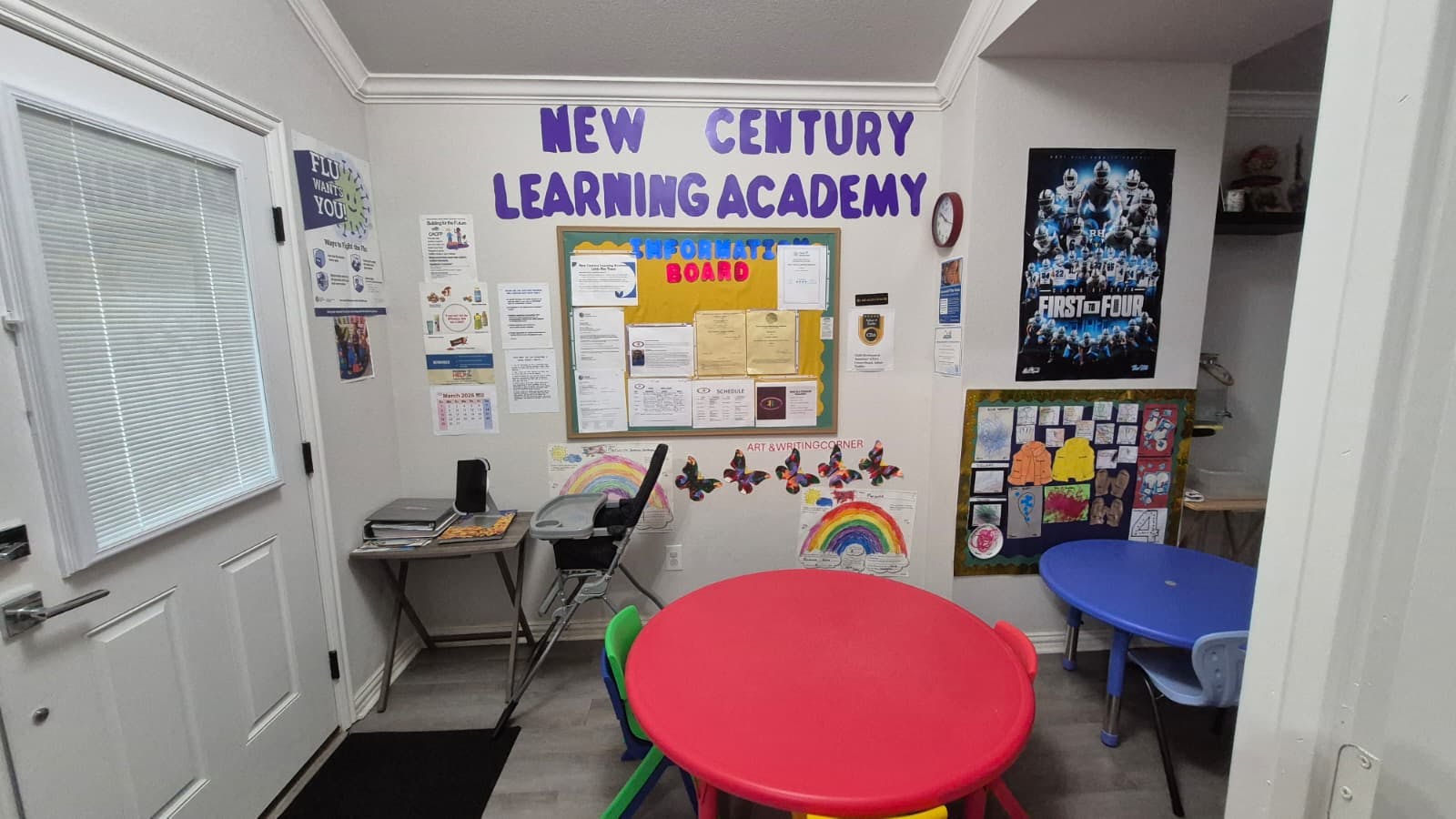 Classroom with text "NEW CENTURY LEARNING ACADEMY", two children's tables, and a bulletin board