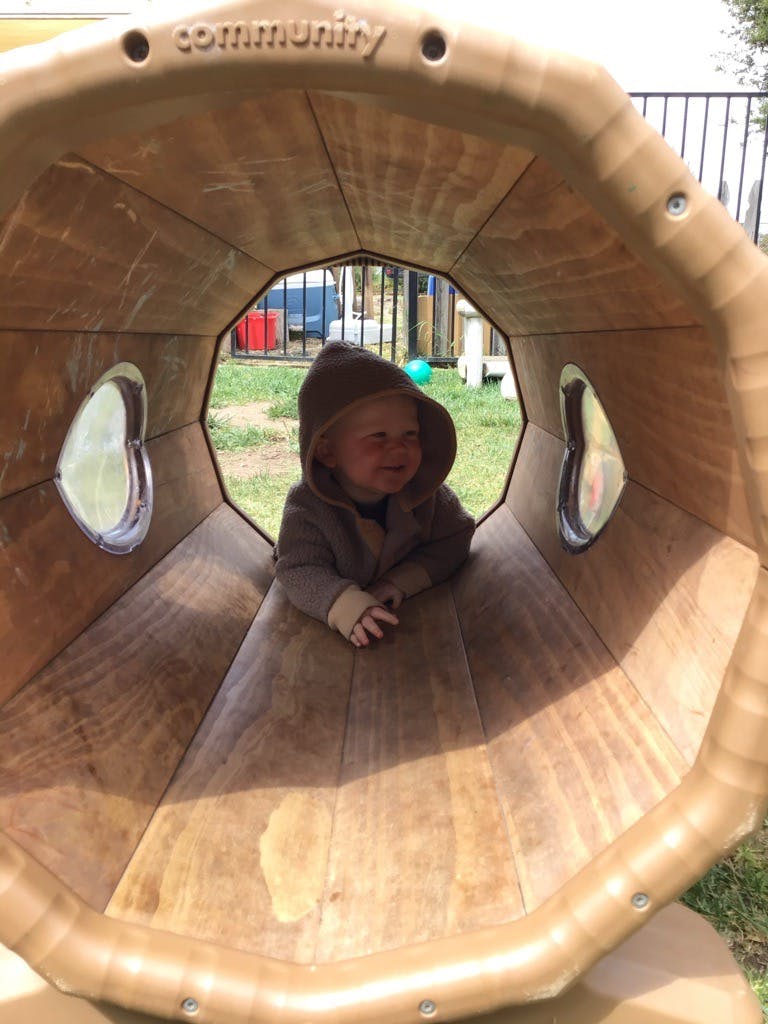Child smiling in a play tunnel