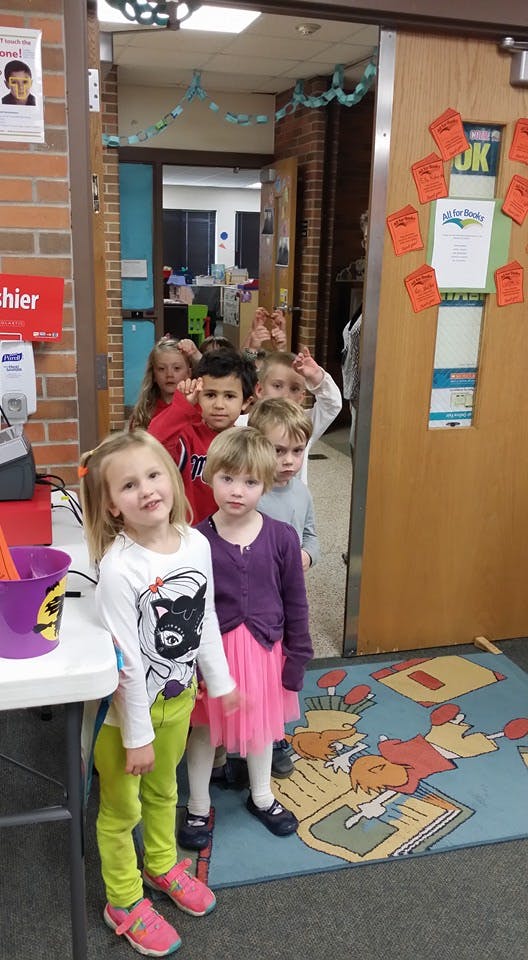Group of children standing in a line in a doorway