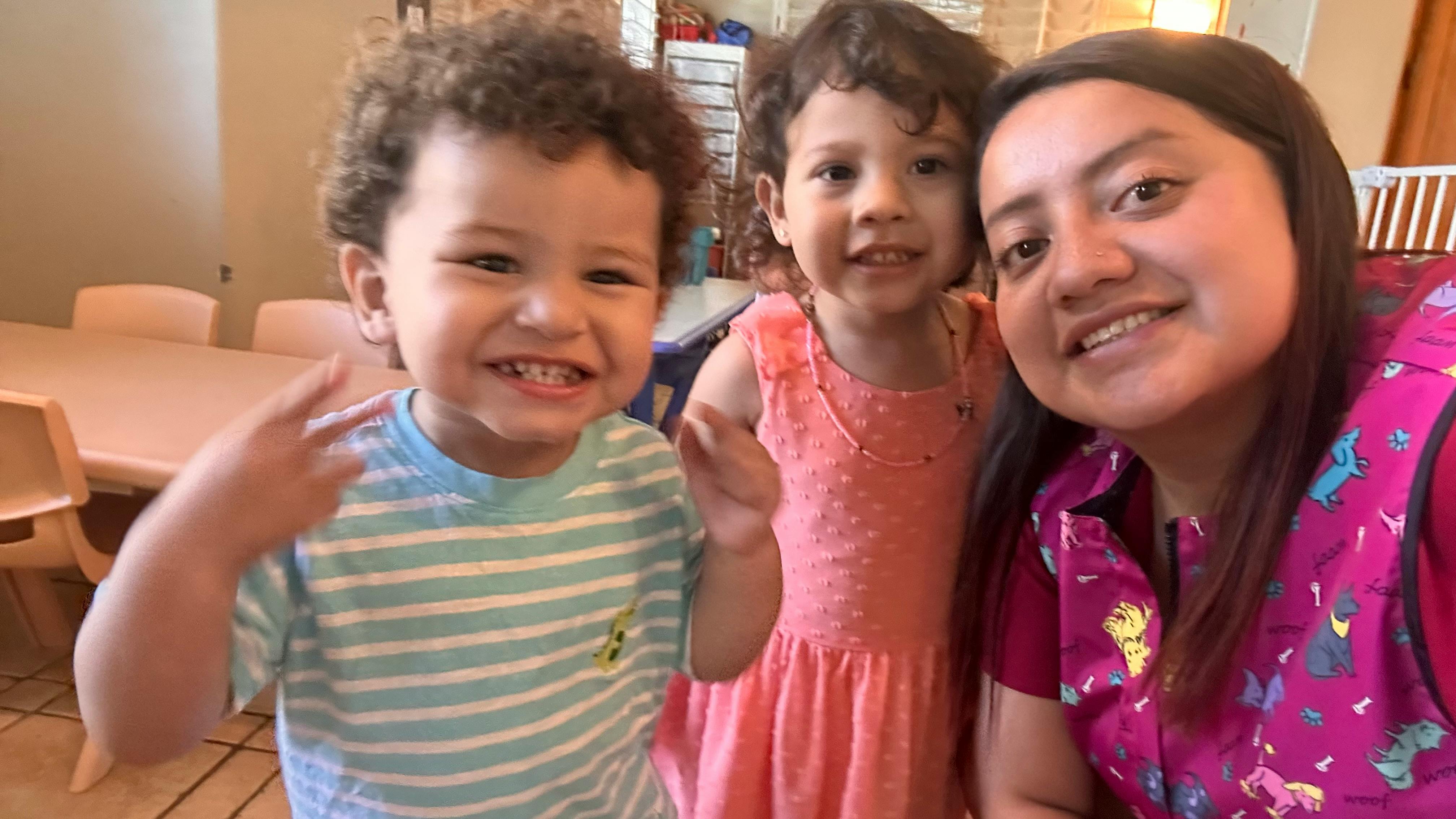 Person with two children in a classroom