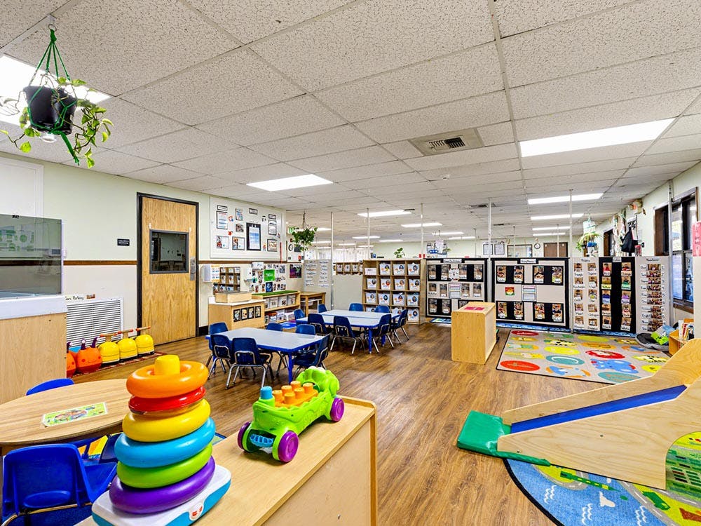 Colorful playroom or classroom with child-sized tables, chairs, and toys